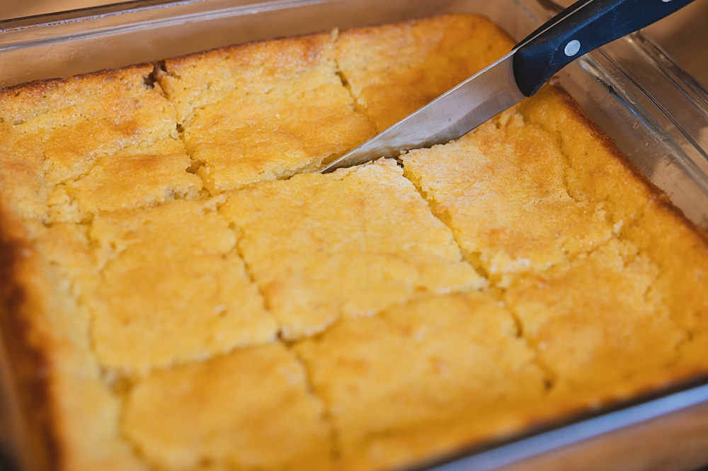 Slice of upgraded Jiffy cornbread with buttery golden top and tender crumb.