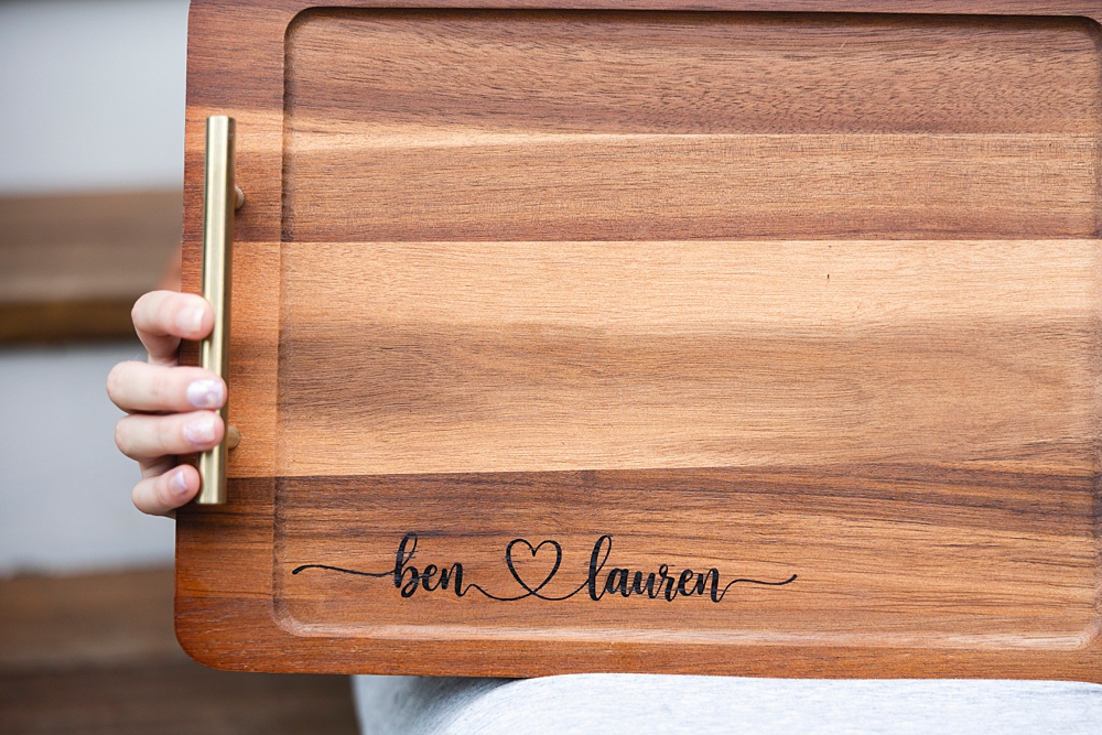 Personalized wooden charcuterie board with custom names created using a Cricut stencil, Applying a removable vinyl stencil to a wooden charcuterie board for a personalized gfit, How to make a personalized charcuterie board without engraving!