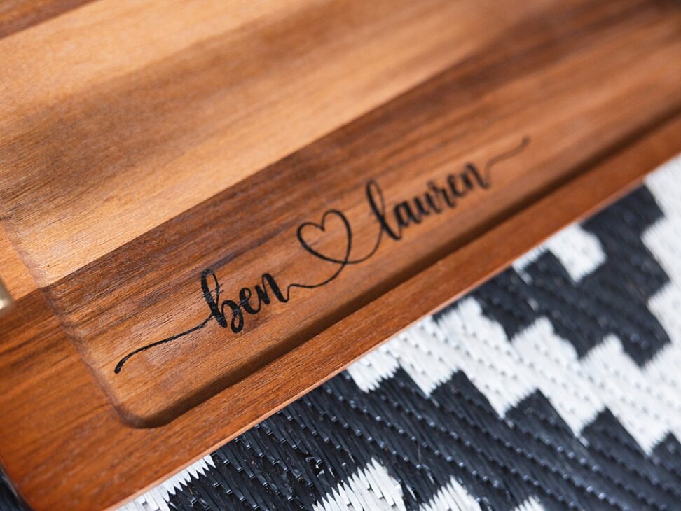 Personalized wooden charcuterie board with custom names created using a Cricut stencil, Applying a removable vinyl stencil to a wooden charcuterie board for a personalized gfit, How to make a personalized charcuterie board without engraving!